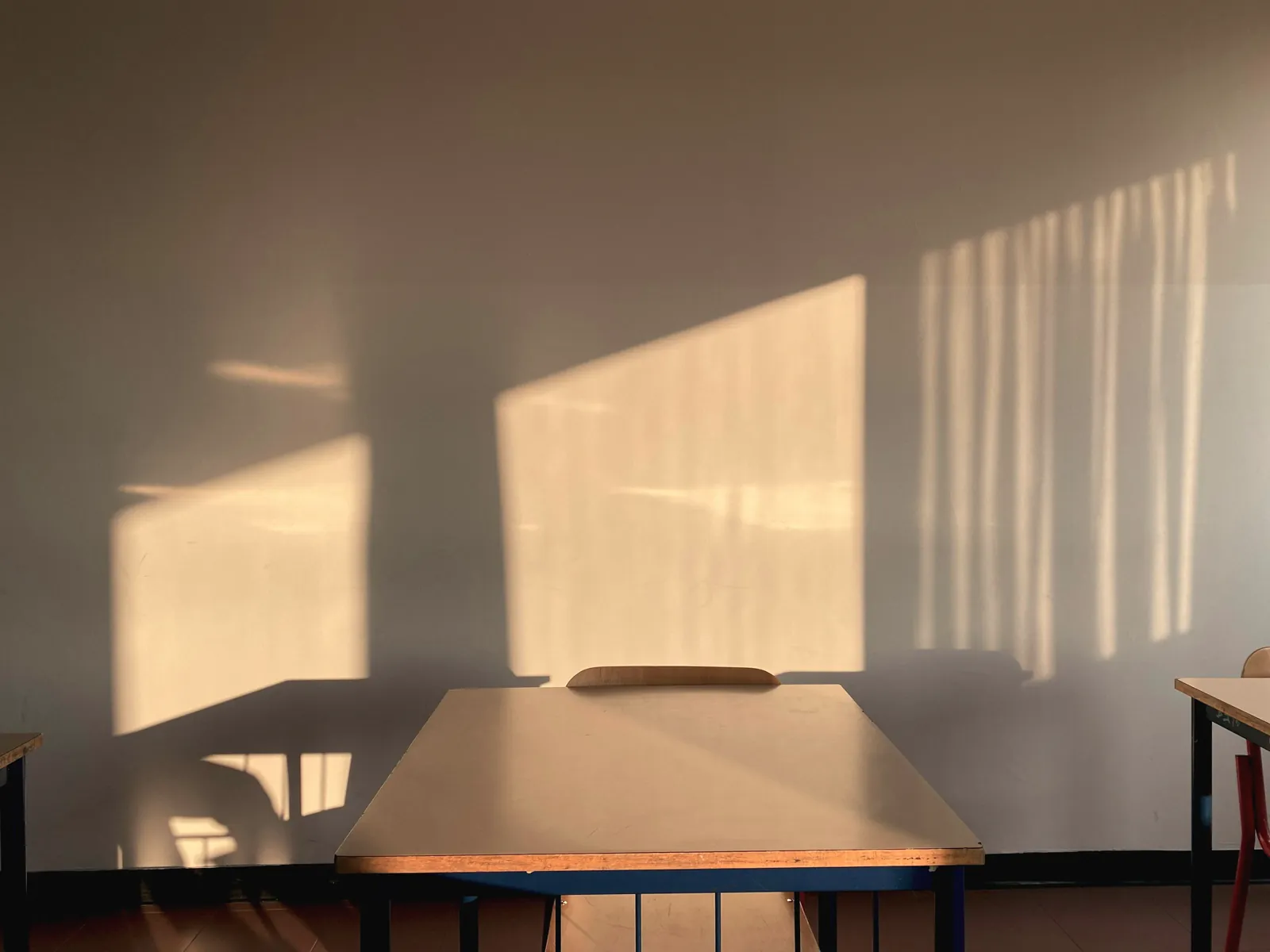An empty desk and chair in late afternoon light